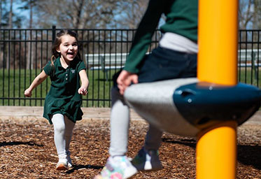 A little girl running to someone at a playground. Links to Gifts That Pay You Income